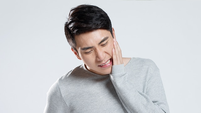 A young man in pain due to canker sores