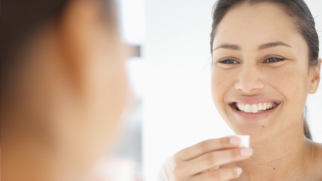 A woman smiling while looking at herself in the mirror