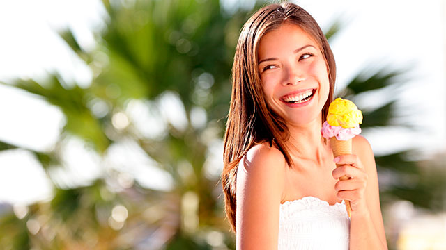 Mujer comiendo helado y sonriendo