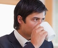 A man is drinking from a cup