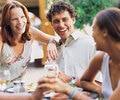 Two couples having a glass of wine in outdoors cafe