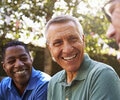 Older male friends socializing in the backyard together