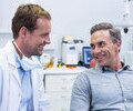 Smiling dentist and patient interacting with each other