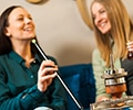 Two happy women are sitting in a bar and smoking hookah