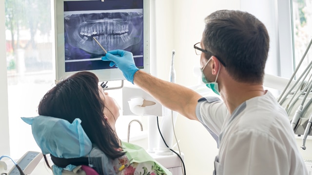 A dentist showing an x-ray to a patient in a dental office. 