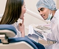 Male dentist examines female patient's teeth