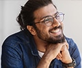A Smiling Man With Eyeglasses And Braces In Home Interior