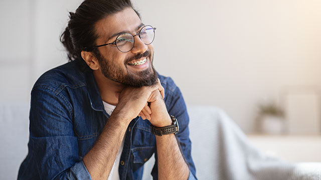 A Smiling Man With Eyeglasses And Braces In Home Interior