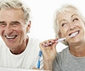 Happy senior couple, brushing teeth in the bathroom