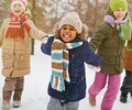A group of four children playing outdoors in the winter time