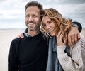 Adult couple smiling and embraced on the beach