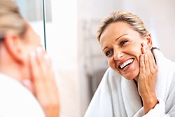 Happy mature woman smiling in the mirror