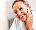 Happy mature woman smiling in the mirror