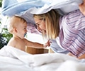 Baby with a pacifier and mother playing