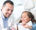 girl at the dentist learning to brush her teeth properly