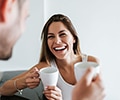 A happy couple holding white cups indoors