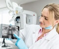 A female dentist showing an x-ray on tablet computer