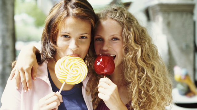 Two girls eating candies