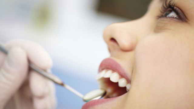 Primer plano de un paciente que le estan revisando la dentadura