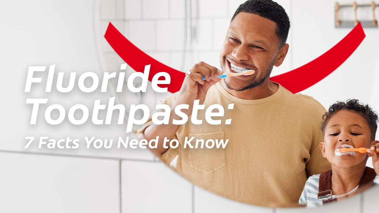 An adult and child smile while brushing their teeth together, with text reading "Fluoride Toothpaste: 7 Facts You Need to Know.
