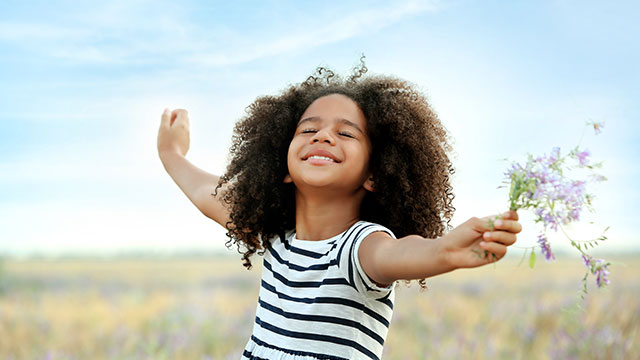 Niña feliz en el campo jugando