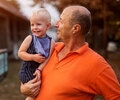 Picture of a proud grandfather holding his grandson and looking at him with love