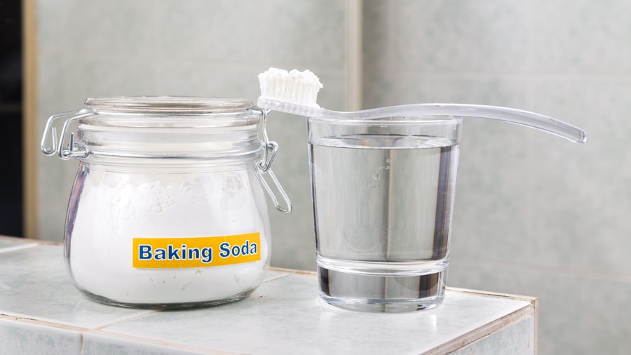 Baking soda, a toothbrush, and a glass of water