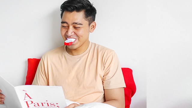 A man doing Colgate LED teeth whitening at home
