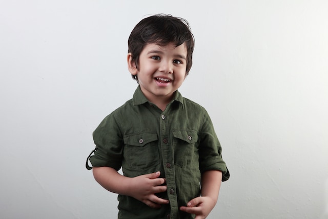A young boy smiling confidently after using tooth space maintainers