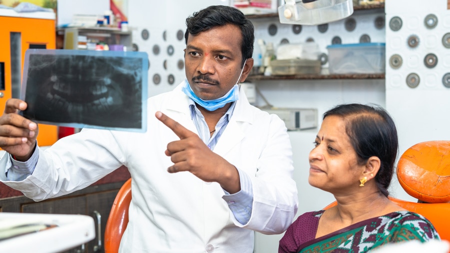 Dentist explaining tonsil stones to woman