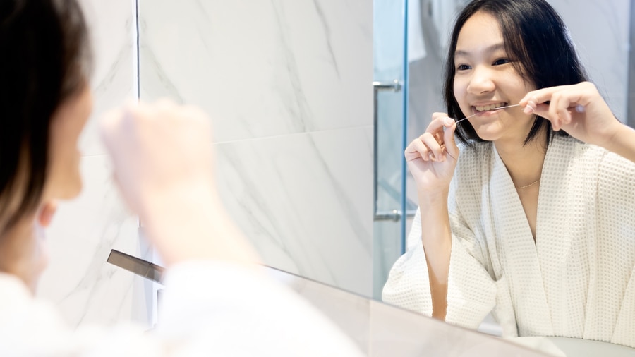 girl flossing teeth as part of gingivitis treatment