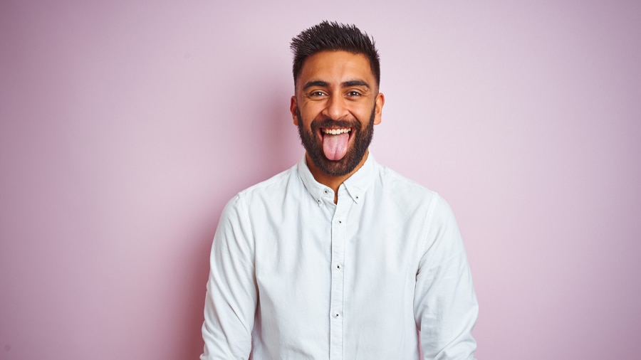Man examines tongue, addressing the bad breath conundrum