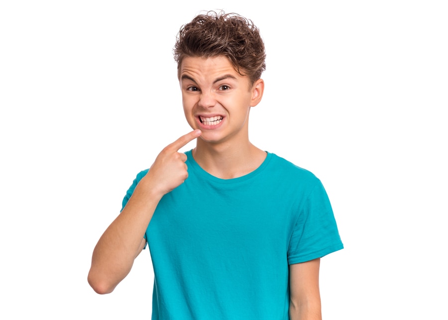 Niño señalando sus dientes