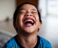 Young boy laughing in home