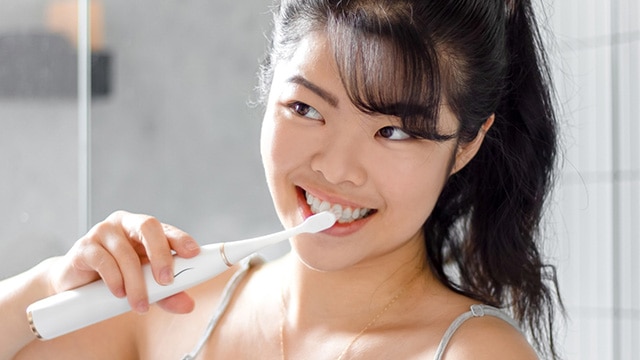 Asian girl brushing teeth