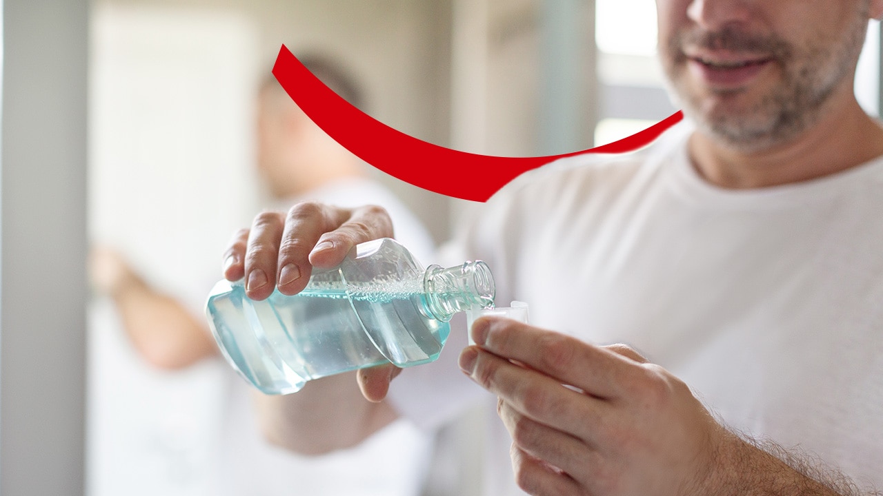 Close-up of a man pouring mouthwash into a cap