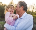Grandpa holding a child in a field