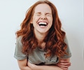 A young woman is laughing with closed eyes 