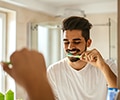 Young man is brushing his teeth