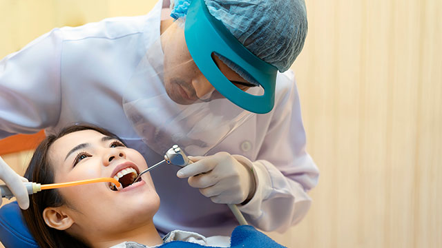 A dentist is treating a female patient