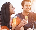 Romantic couple eating ice cream at park