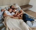Young family in bedroom looking at cell phone