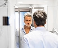 Older man looking at himself in the mirror