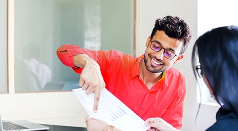 smiling man pointing at something on a piece of paper