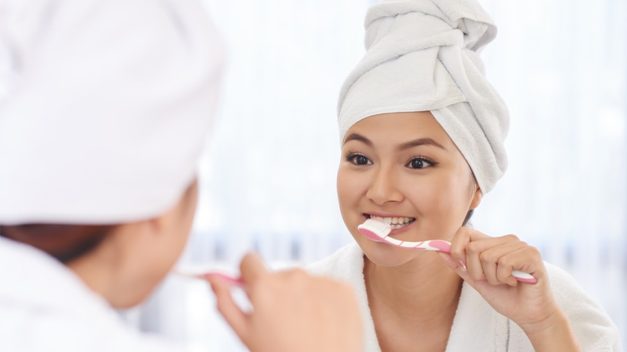 woman brushing teeth to help with gum disease