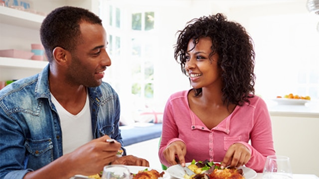 Joven pareja afroamericana comiendo en casa