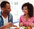 Young African American Couple Eating Meal At Home