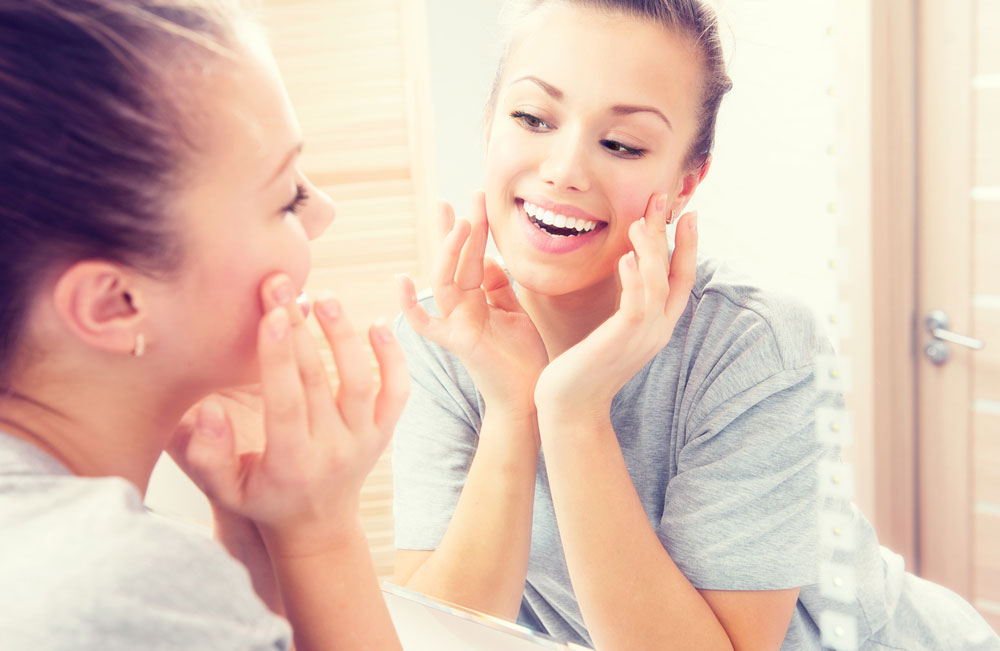 Young woman touching her cheek and smiling