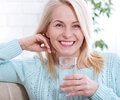 Elder woman smiling while holding a cup of water