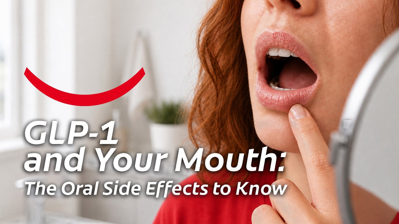 A red-haired woman standing with her mouth open in front of a mirror and examining her lips and mouth for signs of GLP-1 oral side effects. 